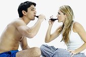 Side profile of a mid adult couple sitting and drinking red wine