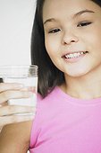 Close-up of a teenage girl holding a glass of water