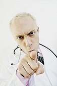 Close-up of a male doctor pointing forward and looking angry