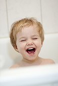 Laughing blond girl in bath