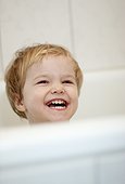 Laughing blond girl in bath