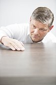 Man checking the surface of a wooden table