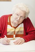 Old woman writing at table