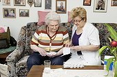 Geriatric nurse explaining medication to old woman