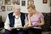 Old and young woman looking into photo album