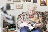 Old woman with puzzle book on couch