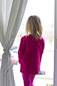 Blond girl standing at the window