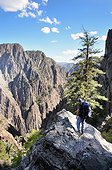 A man stands on a rock outcropping while descending the Tomichi Trail in the Black Canyon of the Gunnison in Colorado.