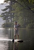 Man rides a SUP on Otter Lake in Greenfield, NH