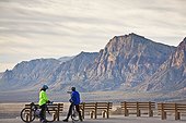 Two cyclists stop to admire the view, Red Rock Canyon National Conservation Area, Nevada, USA.