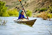 A woman paddles a wooden kayak, Bear Lake.
