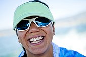 A women in her thirties smiles while wearing a seam foam green visor, Bear Lake, Utah.