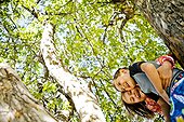 A boy and a girl climb a tree in Garden City, Utah.