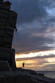 Silhouette of man climbing at sunset in Sardinia, Italy