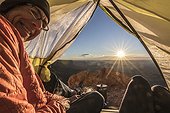 Mature couple watching sunrise from tent, Valley of the Gods, Utah, USA