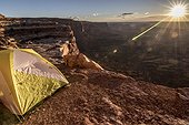 Yellow tent on mountain during scenic sunrise, Valley of Gods, Utah, USA