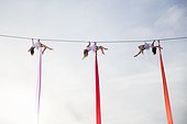 Female aerial silk gymnasts performing against sky 30 meters above ground, Lower Austria, Austria