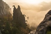 Silhouette of man balancing on highline hanging between two cliffs, Lower Austria, Austria