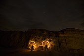 Night time image of a couple light painting and making designs with flashlights in Anza Borrego Desert State Park, California.