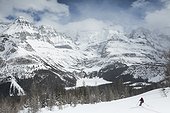 Scenery with mountains and person skiing in winter near Lake O Hara, Yoho National Park, British Columbia, Canada