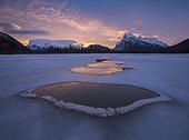 Frozen Vermilion Lake with thawed ice patches in winter at sunrise, Banff National Park, Alberta, Canada