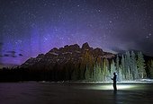 Man fishing in lake at night near Castle Mountain, Banff National Park, Alberta, Canada
