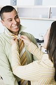 Woman adjusting man's necktie