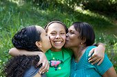 Mother and grandmother kissing preteen girl