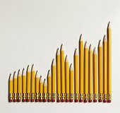 Graph made in yellow pencils with eraser ends. Still life of sharp yellow pencils forming a graph in slow growth