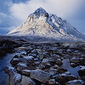 Snow covered mountain by stream. UK,Scotland,Highlands,Buchaille Etive Mor