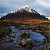 Snow covered mountain by stream. UK,Scotland,Highlands,Buchaille Etive Mor