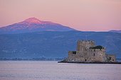 the fortress island of Bourtzi. the fortified island of Bourtzi at dawn with sunlight on the mountain behind