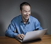 smiling and astonished look of man with laptop