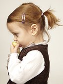 Young girl eating an apple in profile