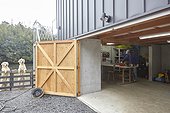 Man in garage workshop with dogs outside