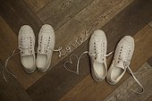 Matching pair of white sneakers laces spell love and make a heart shape