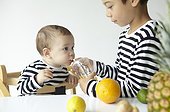 two young boys sharing juice