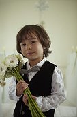 Young boy holding a flower arrangement in a wedding chapel