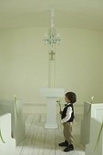 Young boy wearing suit and holding flowers in a wedding chapel