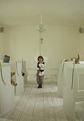 Young boy wearing suit and holding flowers in a wedding chapel with stuffed animals