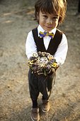 Young boy who is a ring bearer at a wedding wearing suit outside