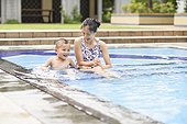 Mother and kid playing in swimming pool