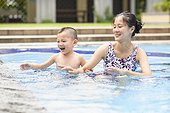 Mother and kid playing in swimming pool