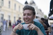 Teenage woman traveling through Central Europe having a coffee at an outdoor cafe.