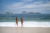 Ipanema Beach girls. Two beautiful girls walking into the ocean in the Posto 9 section of Ipanema Beach in Rio de Janeiro, Brazil.