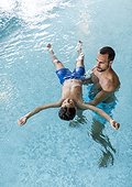 indoor swimming pool ? tanned man in his 30s with short dark hair spends time together with his pre-adolescent 8 years old son in the turquoise blue thermal water, the single father does aqua balance with his child, kid is floating in the water ? to [...]