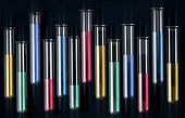 test tubes with different coloured liquids against black background, illustration