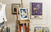 Art studio interior with paintings, artwork, paintbrushes, easel and artist's materials
