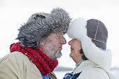 Senior couple in fur-trimmed hats touching noses