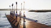 Team of rowers standing with canoe on pier